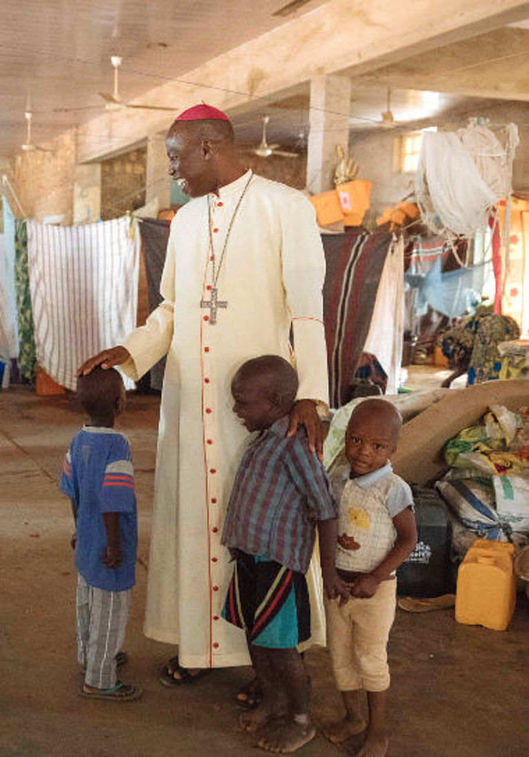Bischof Stephen Mamza spricht mit Kindern, die mit ihren Familien vor Boko Haram geflohen sind.