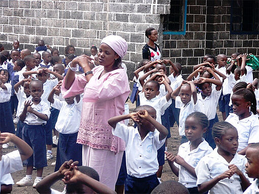 Kinder in Goma wenden unter Anleitung einer Frau die Capacitar-Methode an.
