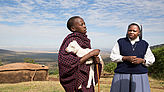 Schwester Lea spricht mit einem Maasai-Jungen, der ein Lamm im Arm hält.