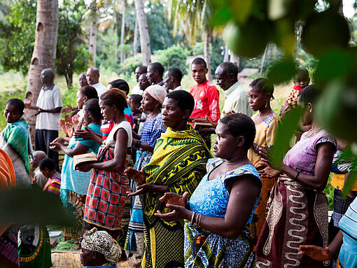 Eine Dorfgemeinschaft in Tansania ist zum gemeinsamen Gebet versammelt.