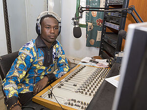 Moderator und Sprecher einer Radiostation in Burkina Faso sitzt im Studio. 