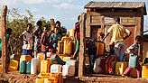 Am Brunnen versammeln sich alle mit bunten Kanistern, denn Wasser ist knapp in der Bergregion des Flüchtlingslagers. 