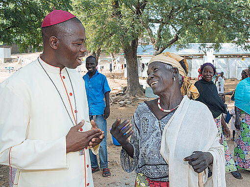 Bischof Stephen Mamza besucht eine Frau im IDP-Camp für Binnenflüchtlinge in Yola.