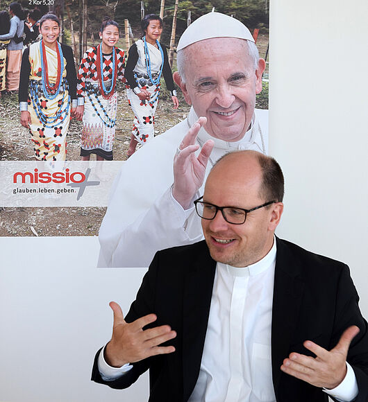 Pfarrer Dirk Bingener vor dem Plakat Papst Franziskus