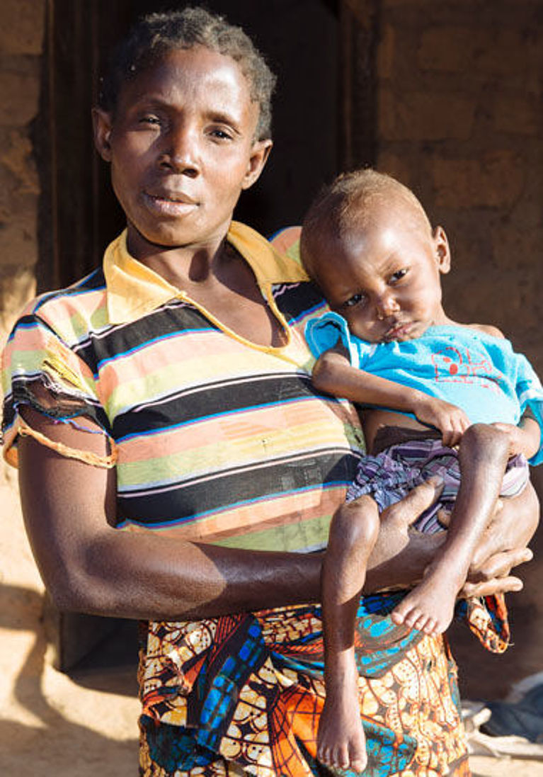 Eine Mutter trägt ihr Kind auf dem Arm in einem Flüchtlingslager in der DR Kongo.