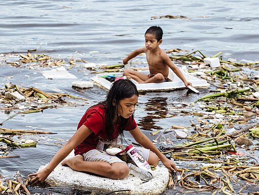Charles und Jay-Ann suchen in den dreckigen Kanälen Manilas nach verwertbarem Plastikmüll. 