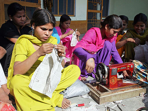 Junge Frauen in Indien lernen nähen.