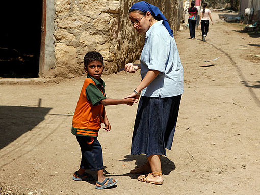 Eine Schwester in Ägypthen hält einen Jungen an der Hand