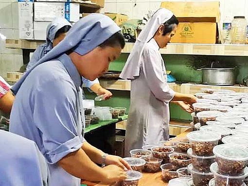 Ordensfrauen packen Lebensmittelpakete für die Bedürftigen.