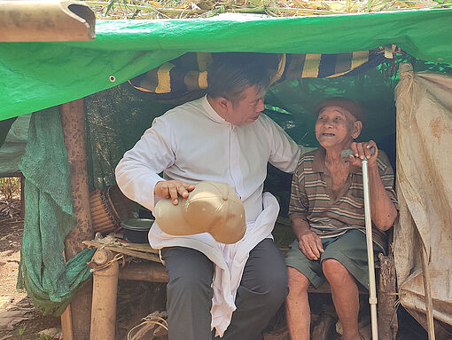 Bischof Celso von Loikaw, Myanmar, spricht mit einem älteren Mann, der vor den Angriffen der Militärjunta fliehen musste.