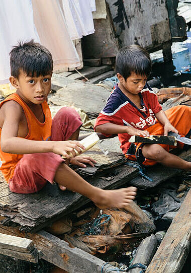 In Manilas Slum Navotas basteln Kinder ihr Spielzeug. 