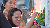 Zwei philippinische Mädchen legen an Allerheiligen Blumen nieder.