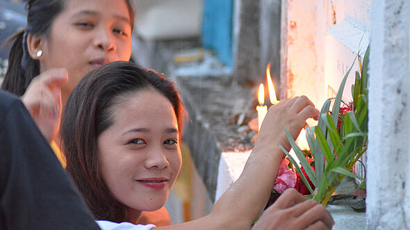 Zwei philippinische Mädchen legen an Allerheiligen Blumen nieder.