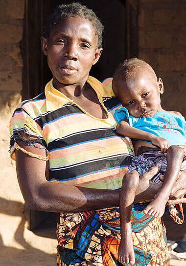 Eine Mutter trägt ihr Kind auf dem Arm in einem Flüchtlingslager in der DR Kongo.