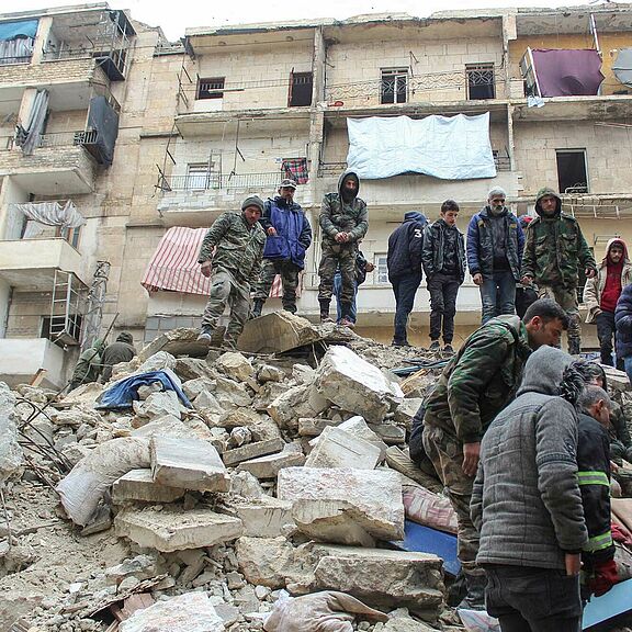 Die Menschen suchen in den Trümmern eines eingestürzten Hauses in Aleppo im Norden Syriens nach Überlebenden.