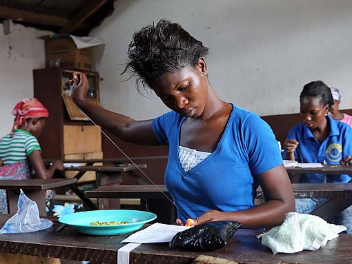 Eine junge Frau lernt Schneidern in Accra, Ghana.