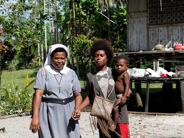 Schwester Thecla Gamog mit einer Frau und deren Kind