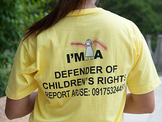 Bild eines gelben Shirts mit der Aufschrift "I'm a defender of children's rights".