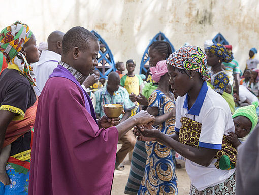Fado, Burkina Faso: Priester teilt die Kommunion aus.