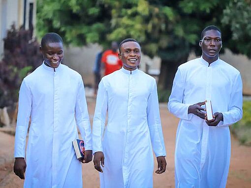 Drei Seminaristen in der Priesterausbildung, Jos, Nigeria, gehen nebeneinander.