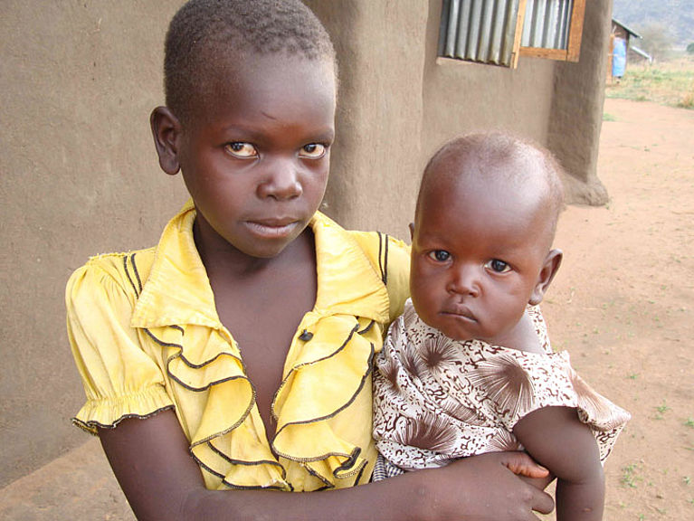 Ein Mädchen hält ein Kleinkind auf dem Arm im Südsudan.