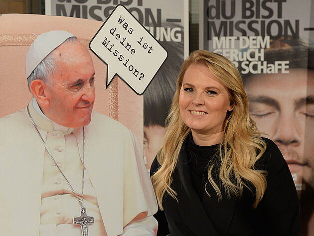 Patricia Kelly und Plakat von Papst Franziskus