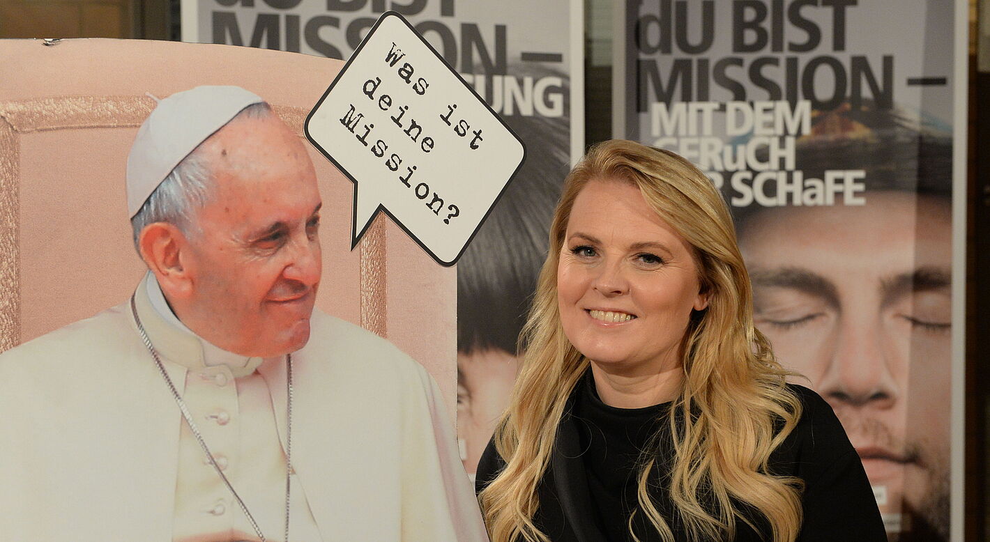 Patricia Kelly und Plakat von Papst Franziskus