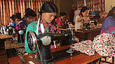 An der Nähmaschine arbeiten diese Frauen, um sich etwas Geld zu verdienen. 