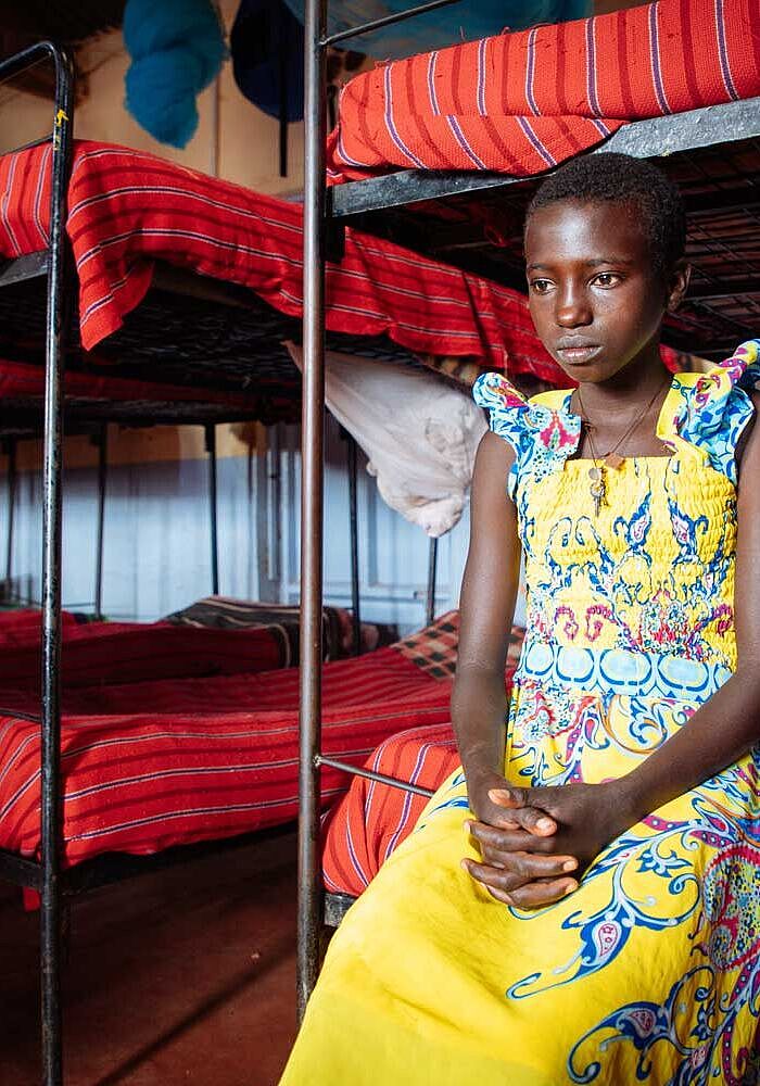 Das Mädchen Caroline sitzt auf ihrem Bett im Rescue Center für Samburu-Mädchen, Kenia.