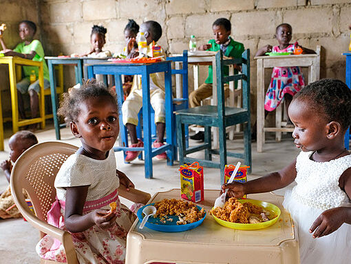 Kinder im Waisenhaus von Schwester Stan essen.