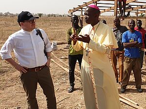 Bischof Stephen Dami Mamza erläutert Präsident Pfarrer Dirk Bingener das von missio geförderte Bauprojekt in der Diözese Yola.