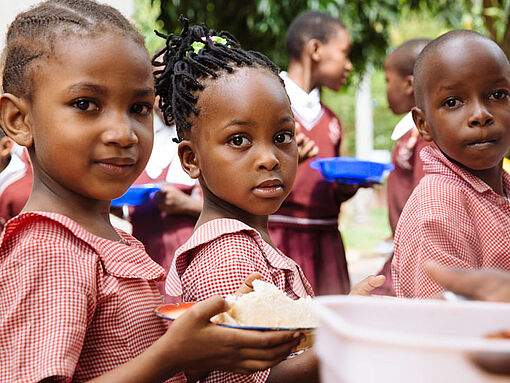 Kinder auf der Insel Sansibar bei der Essensausgabe in der Schule.