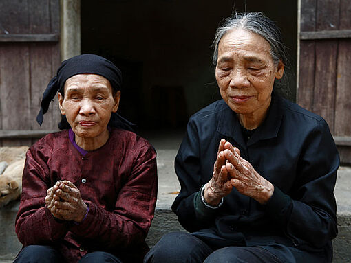 Eine ältere blinde Frau betet zusammen mit einer Schwester, die auch nach ihrem Gefängnisaufenthalt ihren Auftrag der Seelsorge noch wahrnimmt. 