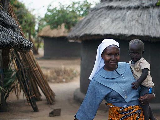 Schwester Joan Atimango, missio-Projektpartnerin im Norden Ugandas, hält ein Kind auf dem Arm.