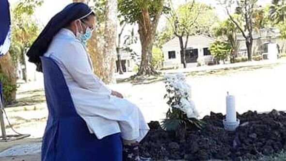 Schwester Constance betet am Grab ihrer verstorbenen Mitschwester. Aufgrund der Corona-Maßnahmen vollzog sie das Beerdigungsritual allein.