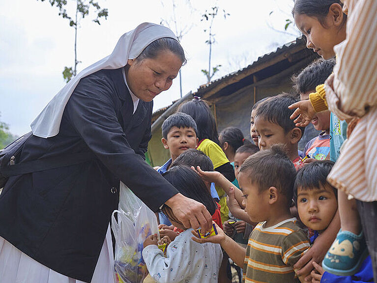 Schwester Bibiana verteilt in Nordostindien Süßigkeiten an Flüchtlingskinder aus Myanmar