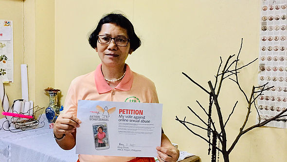 Rhoy Dizon, Vizedirektorin von Action for Nurturing Children and Environment (ANCE), hält die unterzeichnete Petition in den Händen..