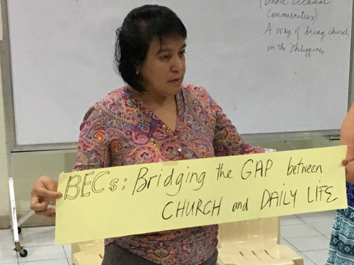 Eine Frau aus den Philippinen hält ein Banner mit der Aufschrift „Bridging the GAP between CHURCH and DAILY LIFE”.