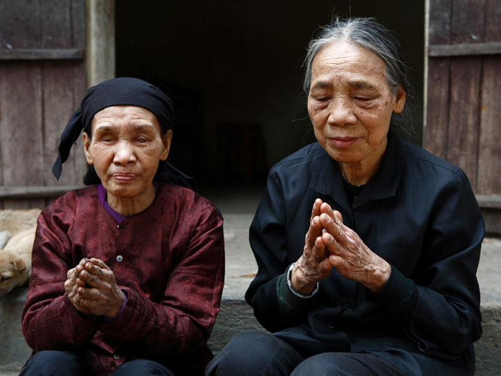 Eine ältere blinde Frau betet zusammen mit einer Schwester, die auch nach ihrem Gefängnisaufenthalt ihren Auftrag der Seelsorge noch wahrnimmt. 